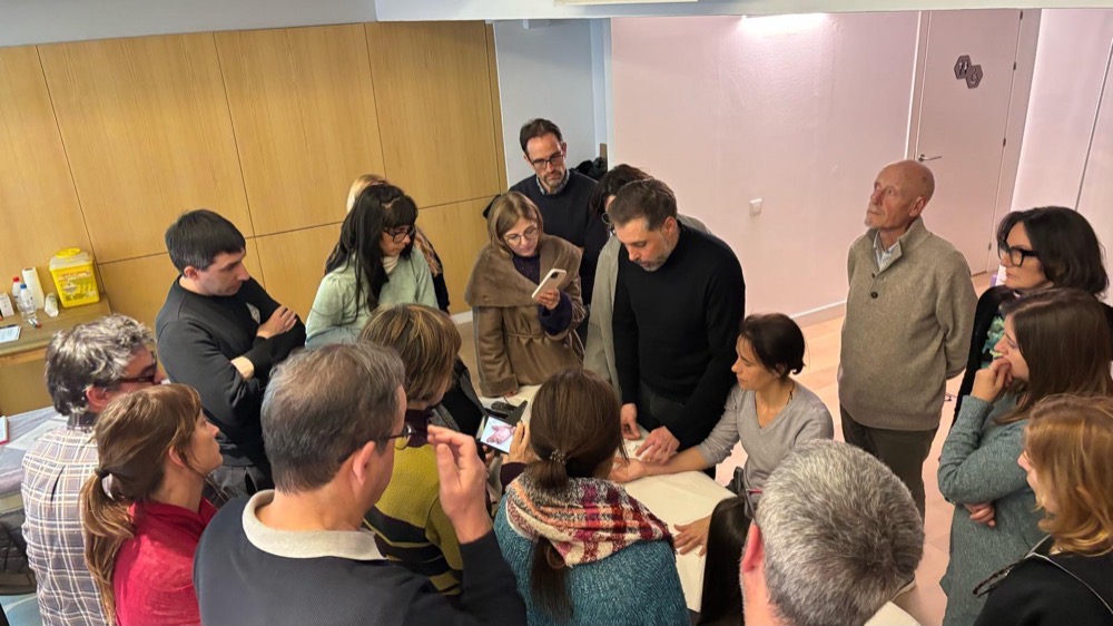 Demostración práctica con el grupo alrededor de la camilla